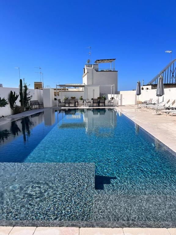Outdoor infinity pool with travertine deck at Zahra Superior Suite, Sannicola
